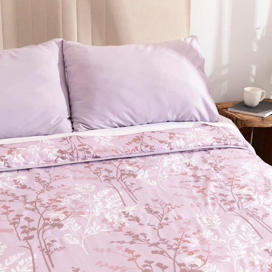 Primer plano del estampado floral blanco y tierra de edredón confort lila.