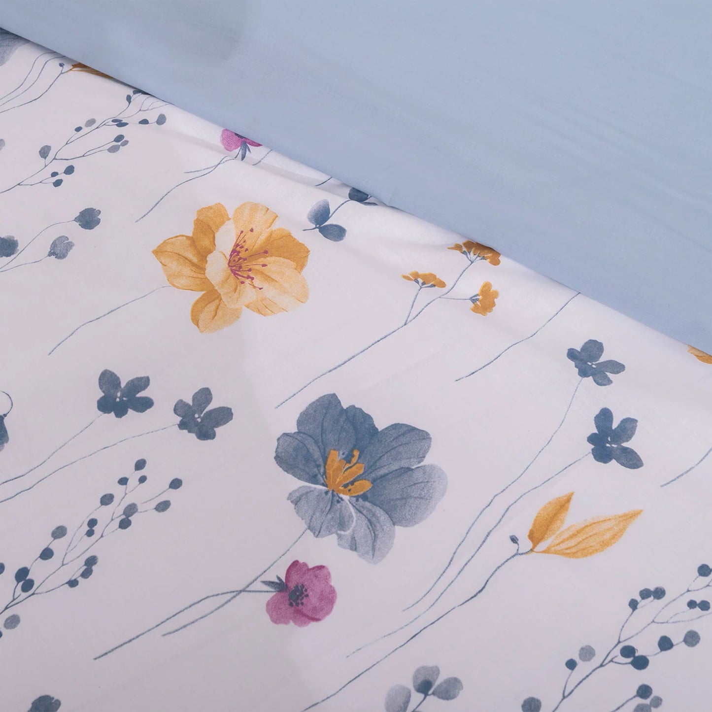 Primer plano del estampado de flores azules y hojas de la funda nórdica