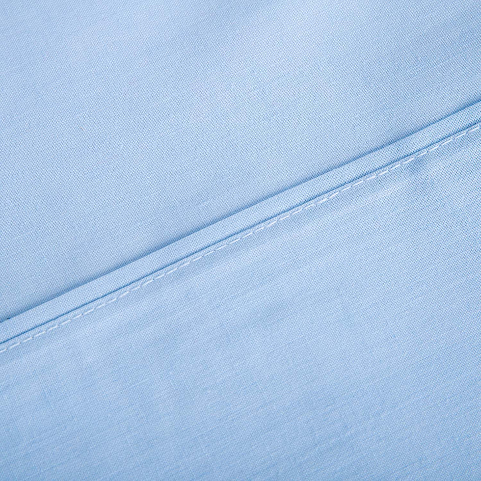 Primer plano del tejido transpirable y costuras reforzadas de las sábanas de verano azul celeste, tacto suave y antipeeling