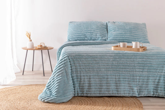 Edredón Jacquard color agua marina con diseño labrado sobre cama matrimonial.