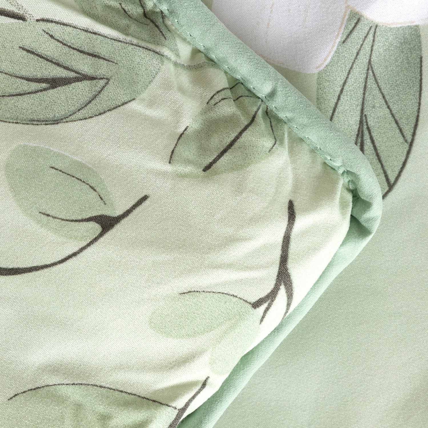 Detalle del borde ribeteado y esquinas redondeadas de edredón confort verde