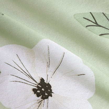 Primer plano del estampado floral blanco y tierra de edredón confort verde