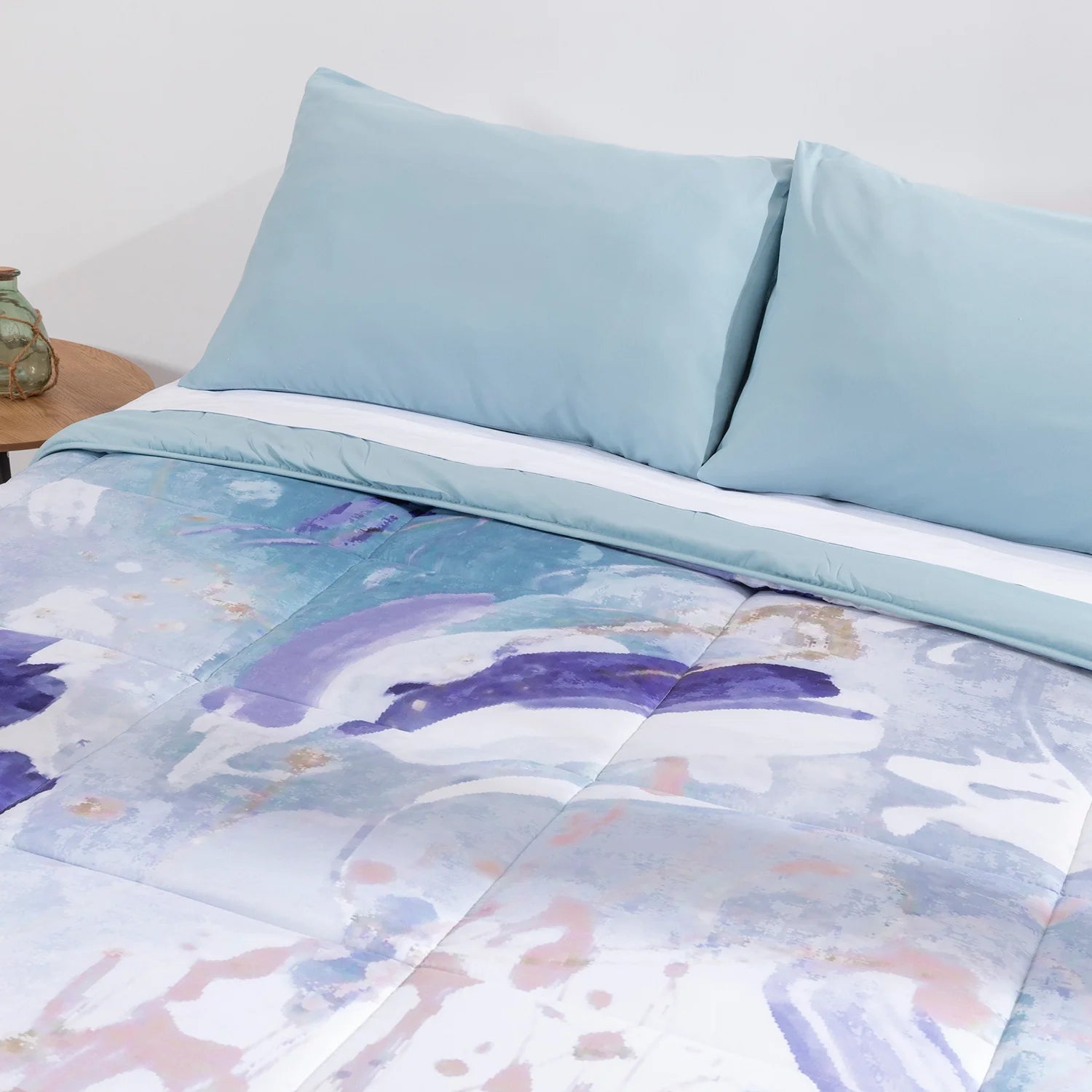 Habitación decorada con edredón confort azul y cojines a juego de la marca Karamelo.