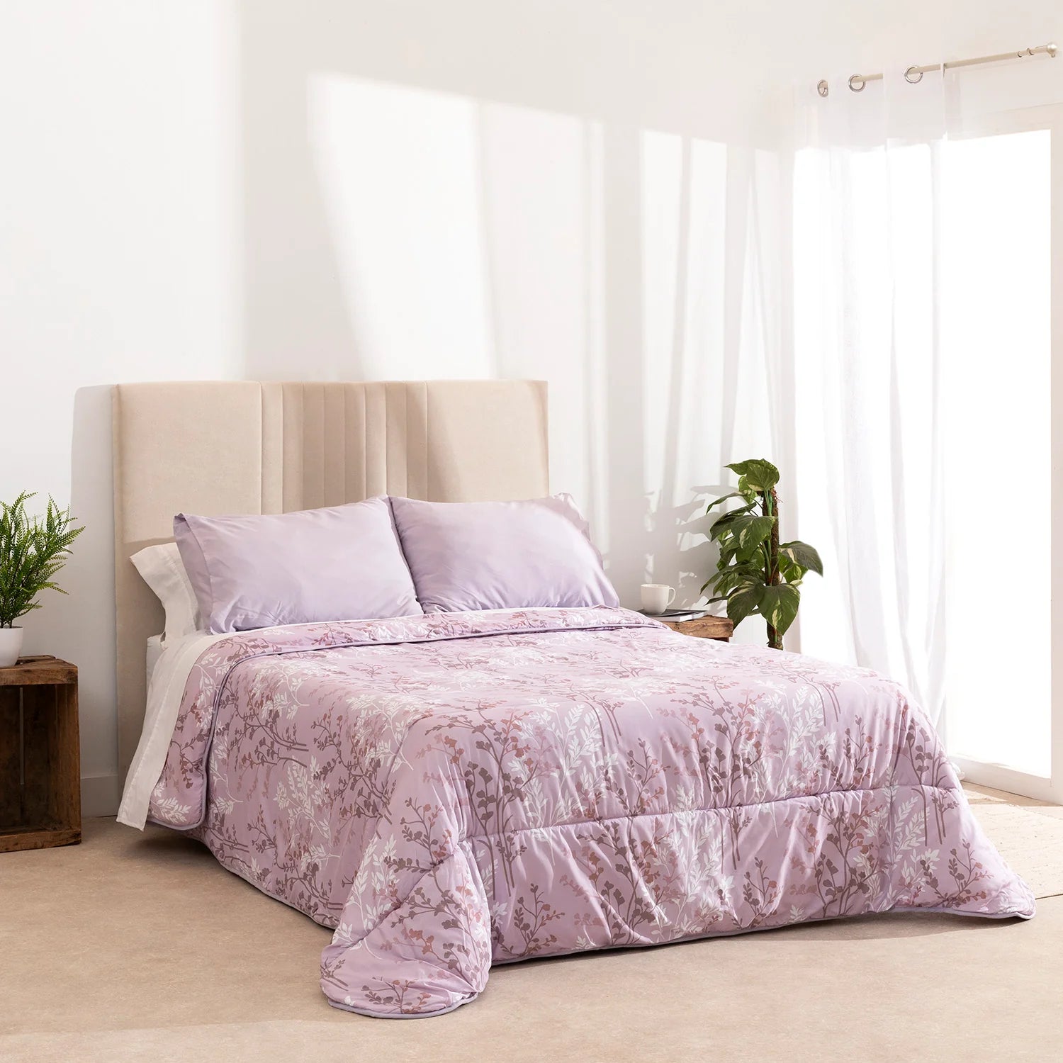 Edredón confort lila con diseño botánico sobre cama de dormitorio moderno.