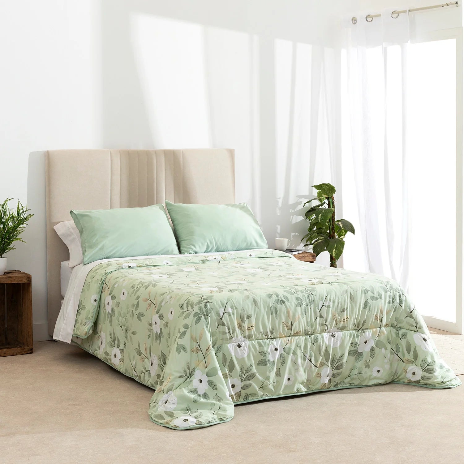 Edredón confort verde con estampado de hojas blancas en dormitorio acogedor.