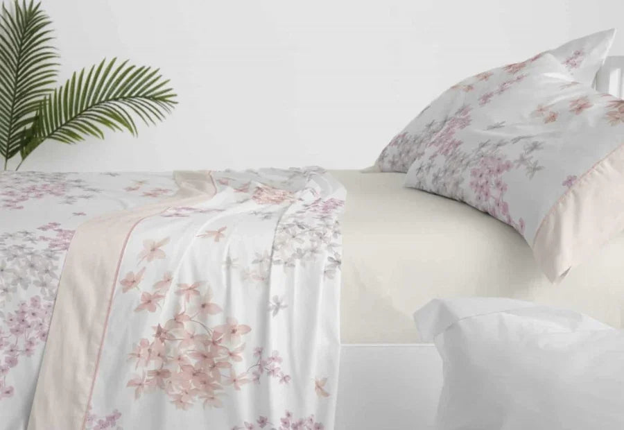 Detalle del estampado floral en tonos Beige/crema, gris y violeta del juego de sábanas Claro de Luna de Burrito Blanco.