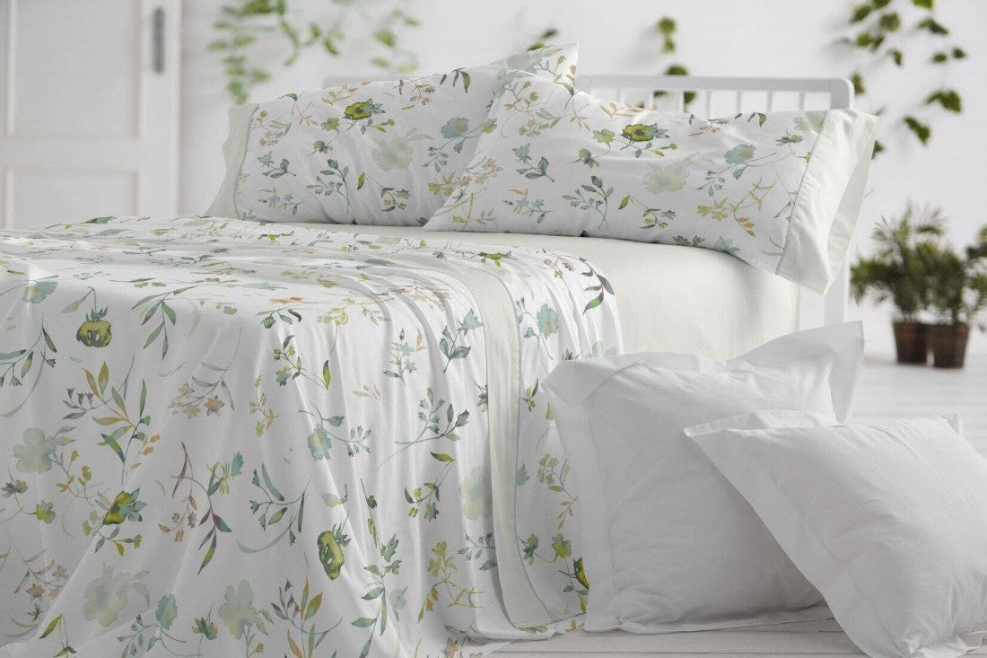 Juego de sábanas de verano con estampado floral acuarelado en tonos menta y turquesa sobre cama blanca