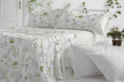 Juego de sábanas de verano con estampado floral acuarelado en tonos menta y turquesa sobre cama blanca