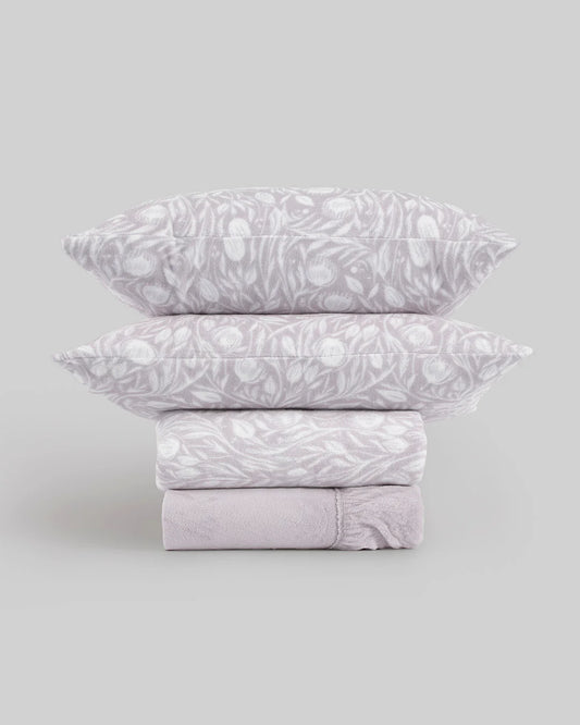 Juego de sábanas de coralina lila con estampado floral.