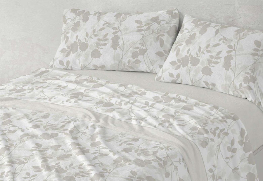 Primer plano del estampado floral de las sábanas de coralina 240 gr/m² Burrito Blanco.