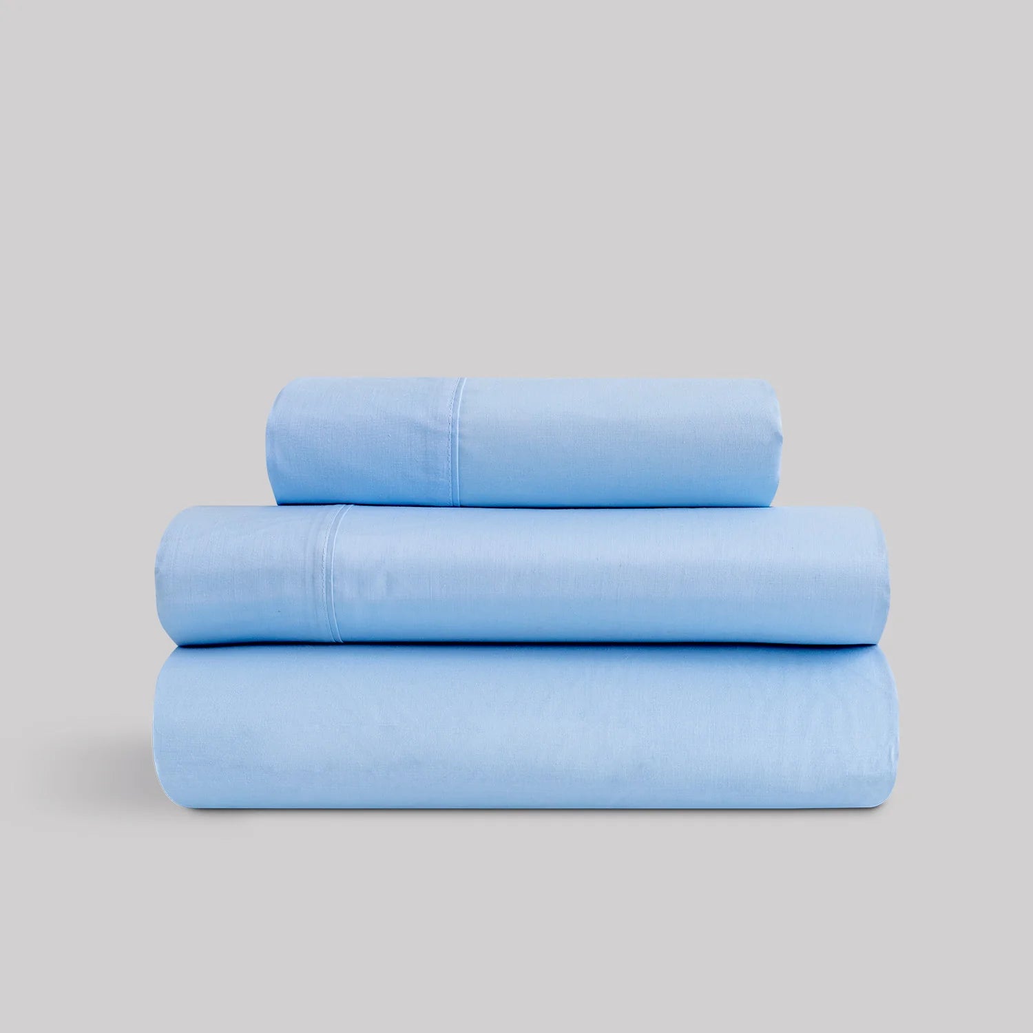 Juego de sábanas de verano color azul celeste marca Karamelo dobladas, compuestas de algodón y poliéster para cama de 90 a 180.
