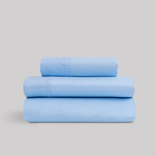Juego de sábanas de verano color azul celeste marca Karamelo dobladas, compuestas de algodón y poliéster para cama de 90 a 180.